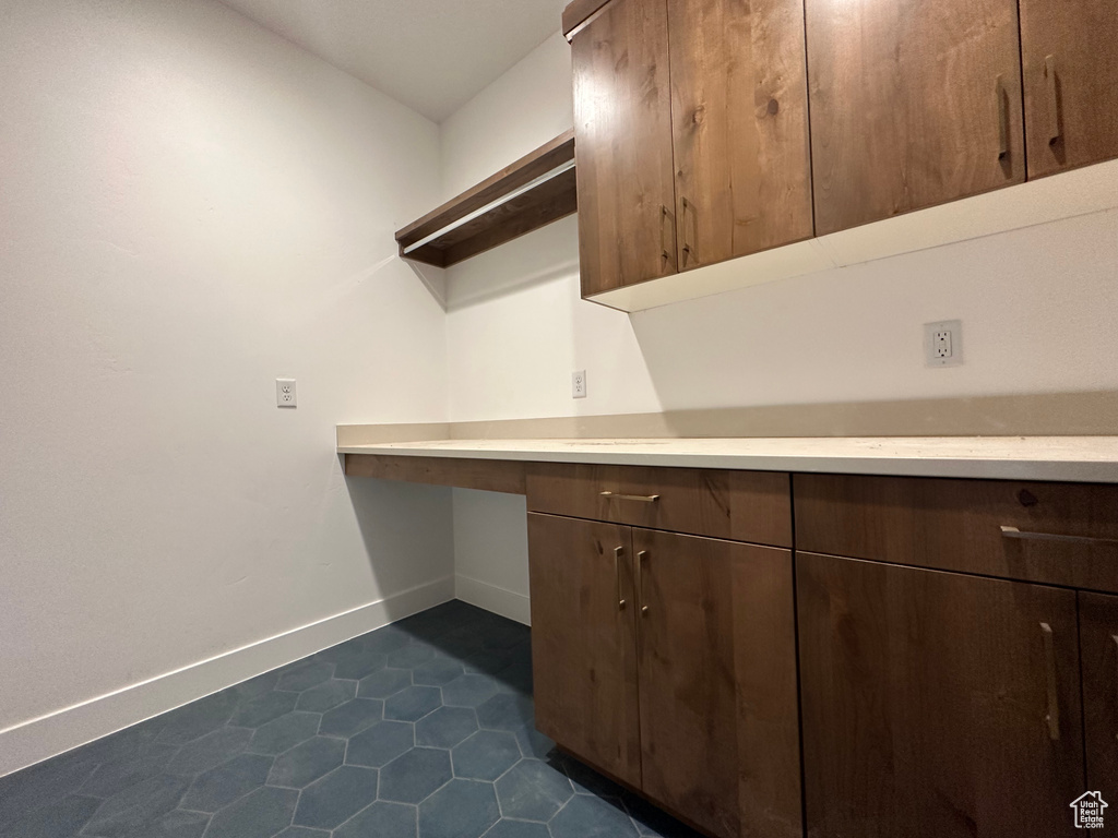 Laundry room featuring dark tile patterned floors