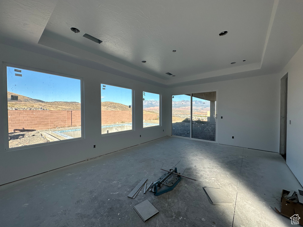 Unfurnished room featuring a mountain view and a raised ceiling