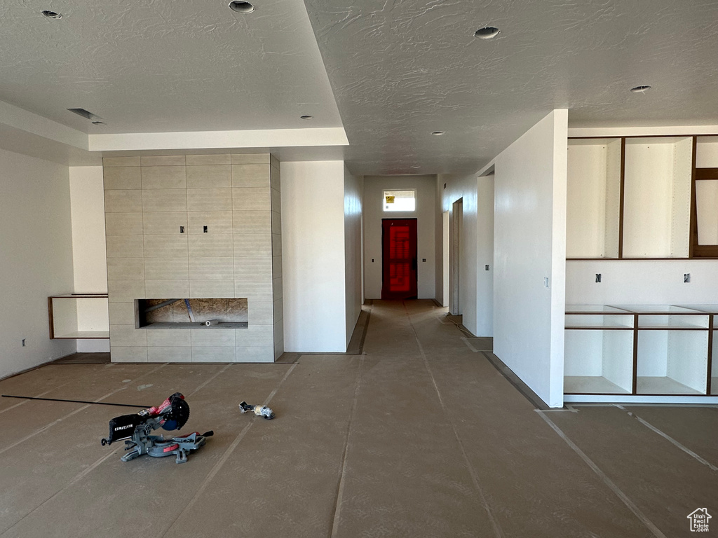 Unfurnished living room featuring a textured ceiling and a fireplace