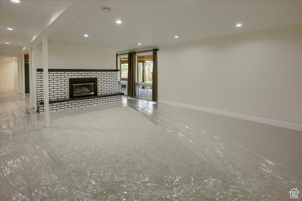 Unfurnished living room featuring a brick fireplace