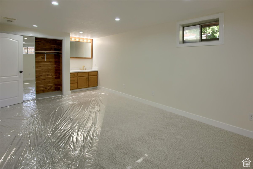 Unfurnished bedroom featuring light colored carpet, sink, and ensuite bathroom