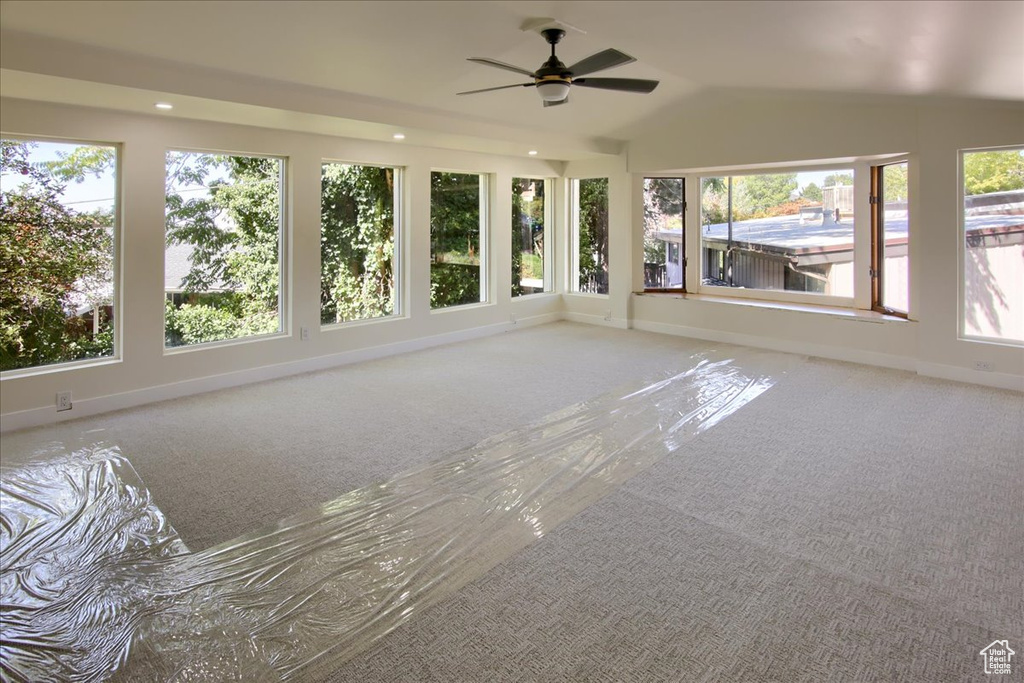 Unfurnished sunroom with a wealth of natural light, lofted ceiling, and ceiling fan