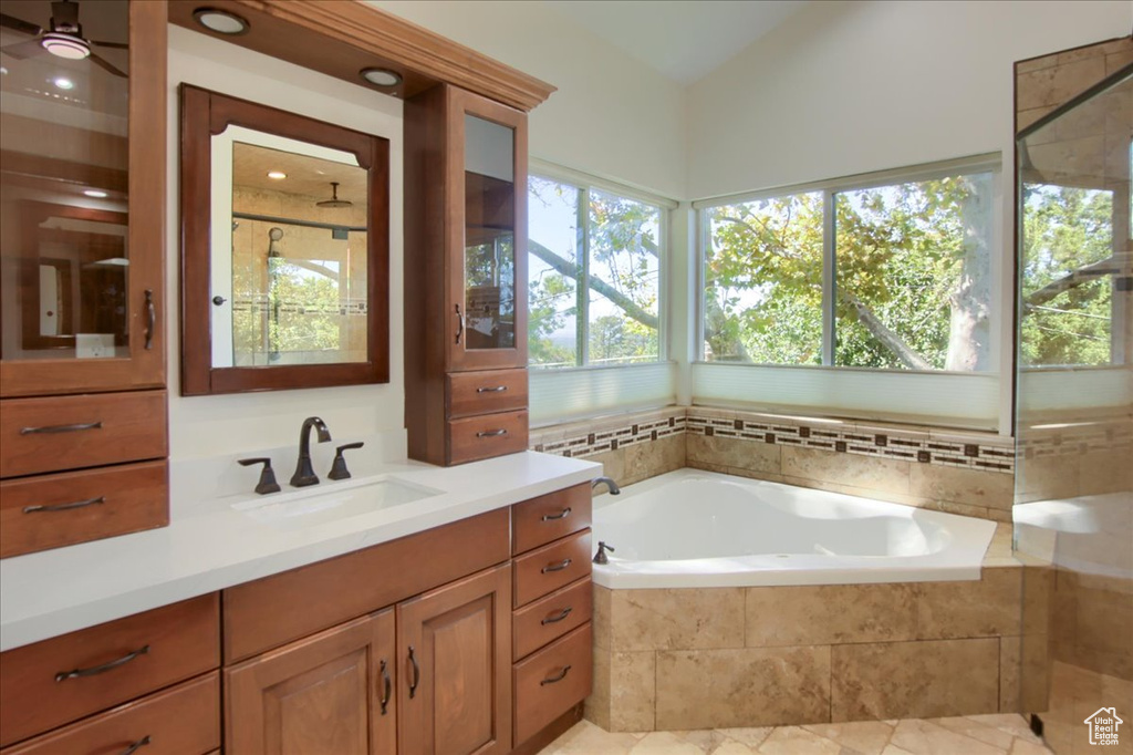 Bathroom with tile patterned flooring, independent shower and bath, and vanity