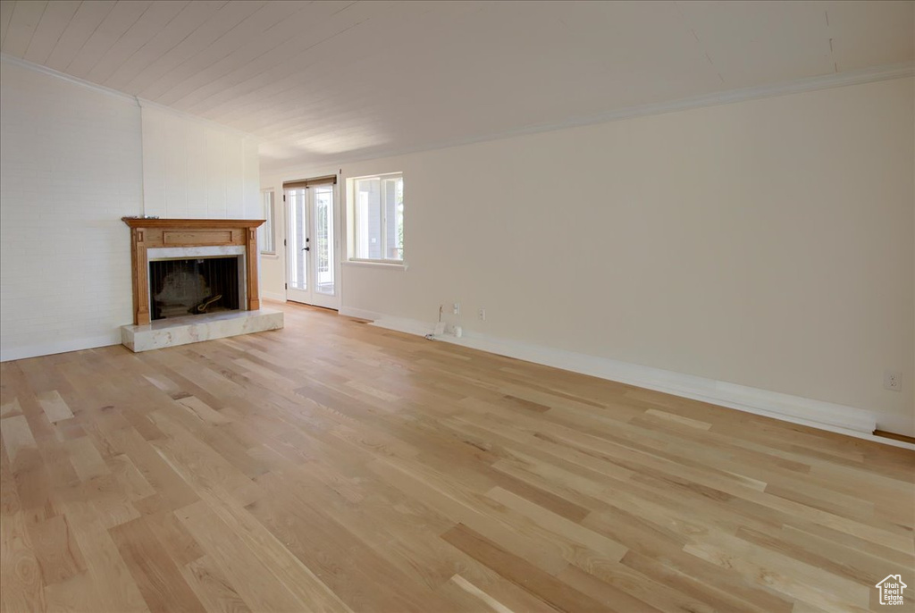 Unfurnished living room with crown molding and light hardwood / wood-style floors