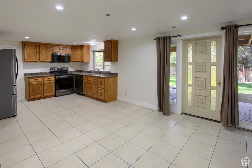 Kitchen with black appliances, sink, and light tile patterned floors