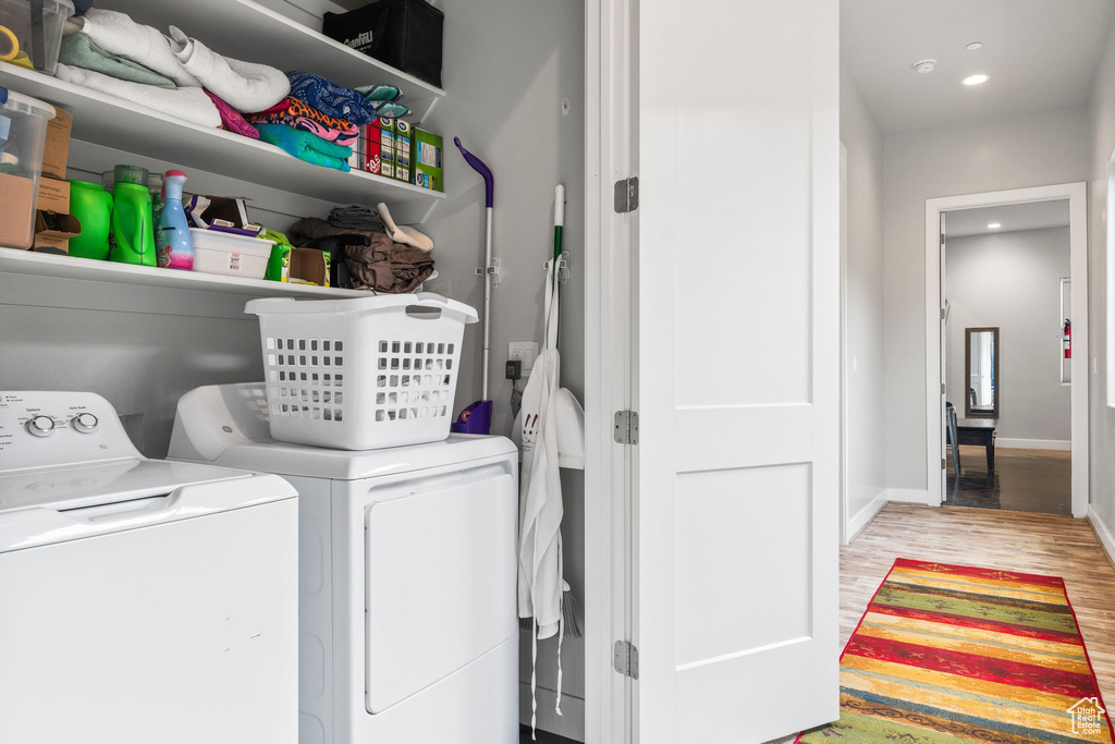 Washroom featuring separate washer and dryer and hardwood / wood-style flooring