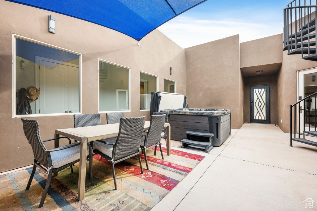 View of patio / terrace with a balcony and a hot tub