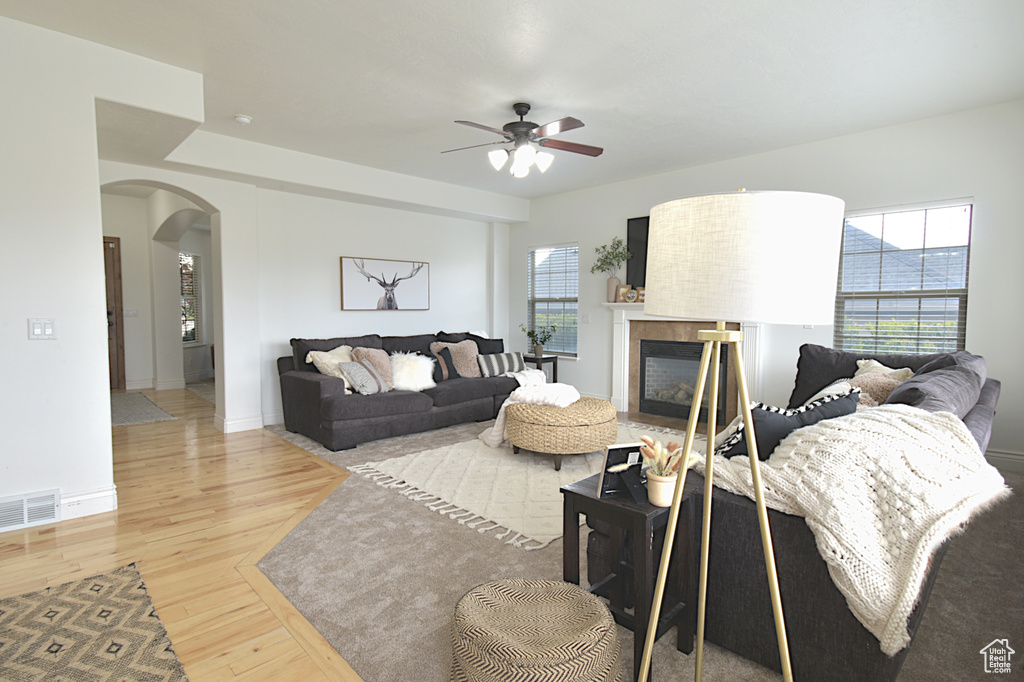 Living room featuring ceiling fan, hardwood / wood-style flooring, and a healthy amount of sunlight