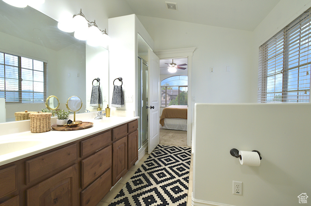 Bathroom with vanity, vaulted ceiling, ceiling fan, and tile patterned floors