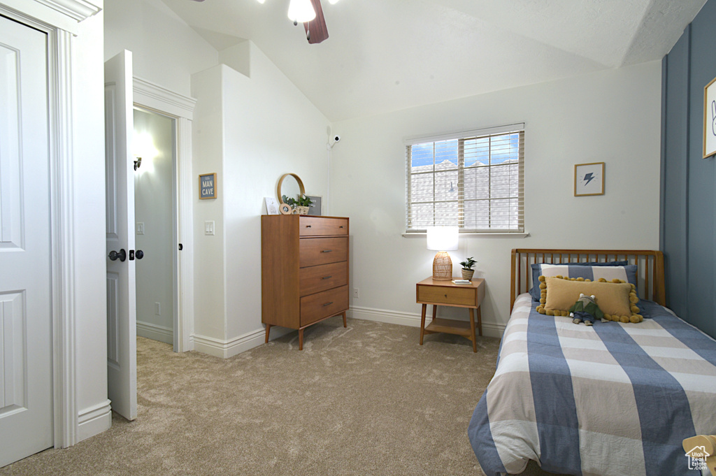 Carpeted bedroom with vaulted ceiling and ceiling fan