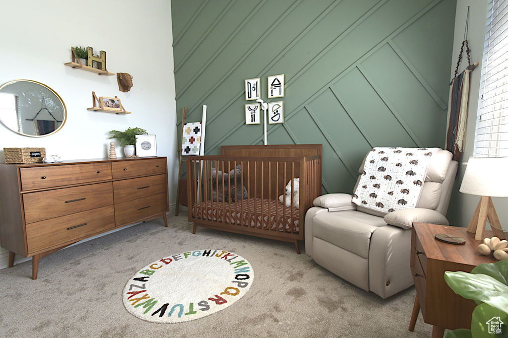 Bedroom featuring a crib and light colored carpet