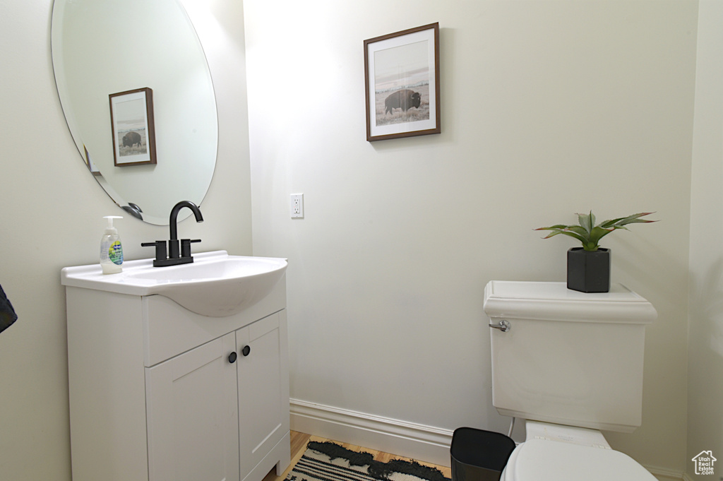 Bathroom featuring wood-type flooring, vanity, and toilet