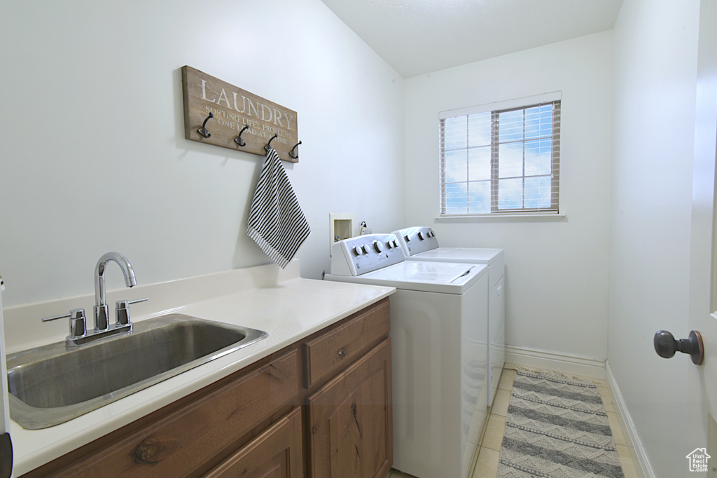 Laundry room featuring cabinets, washing machine and dryer, light tile patterned flooring, and sink