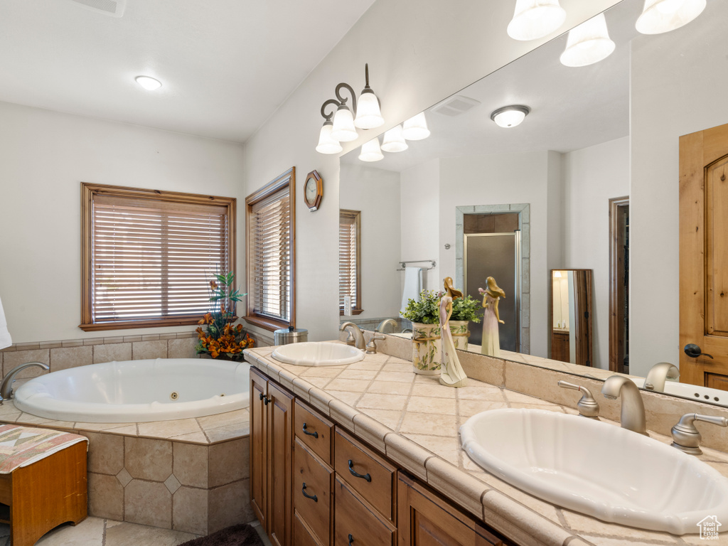 Bathroom featuring vanity, separate shower and tub, a chandelier, and tile patterned floors