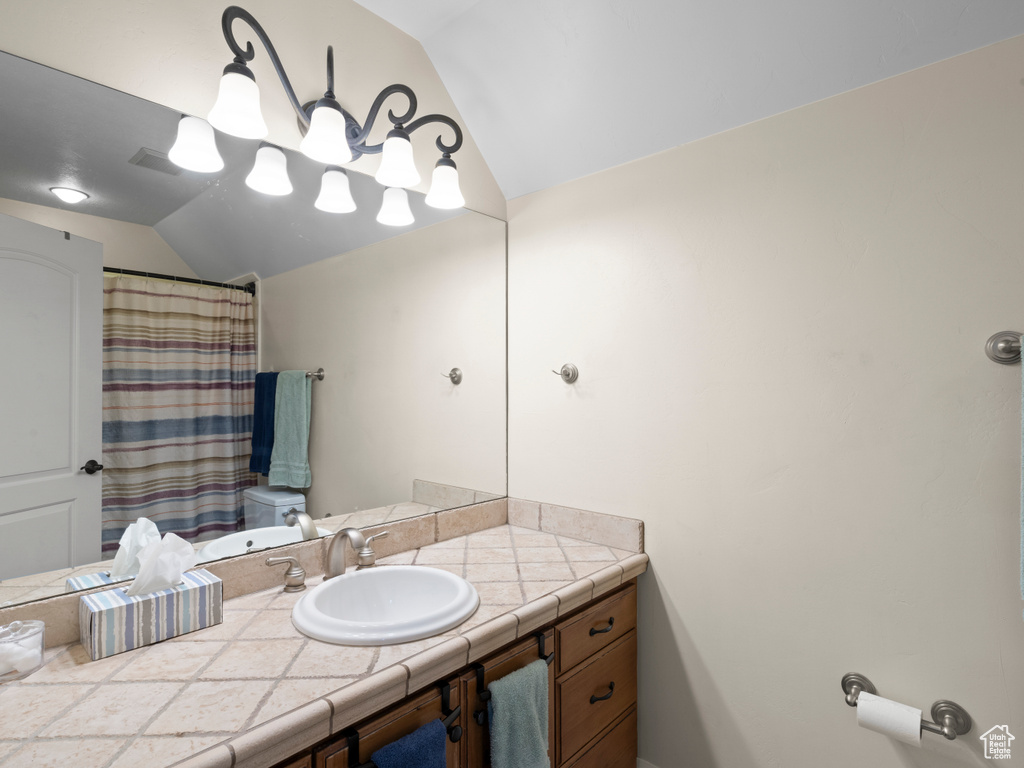 Bathroom with vanity, vaulted ceiling, and toilet