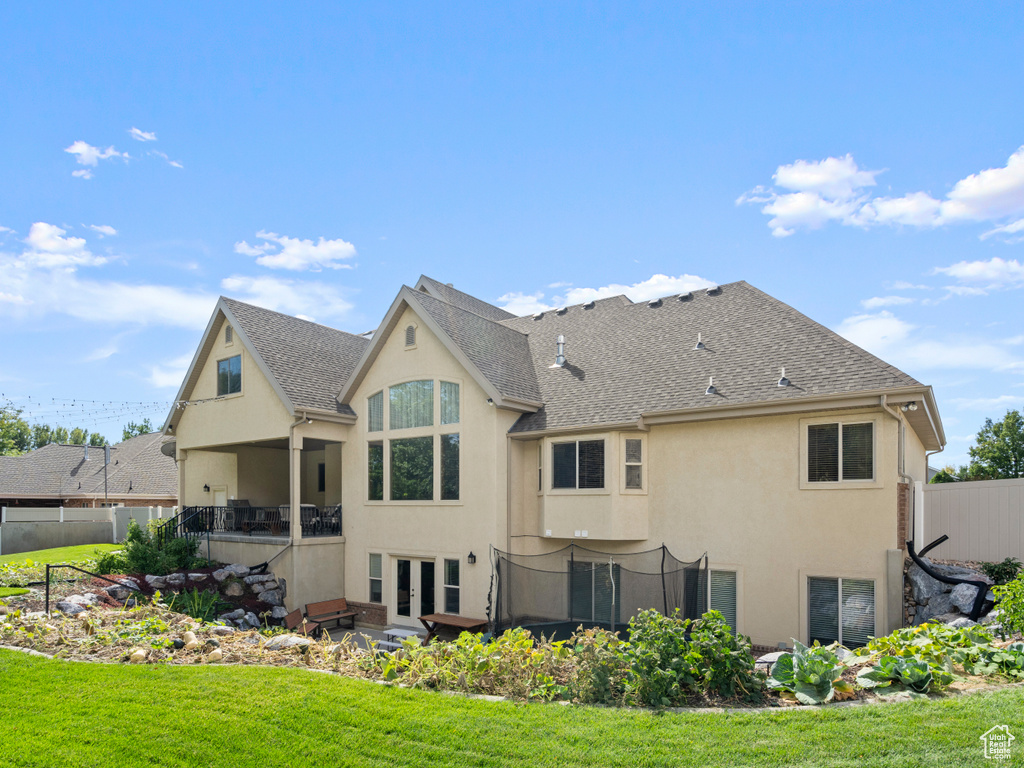 Back of property with french doors and a lawn