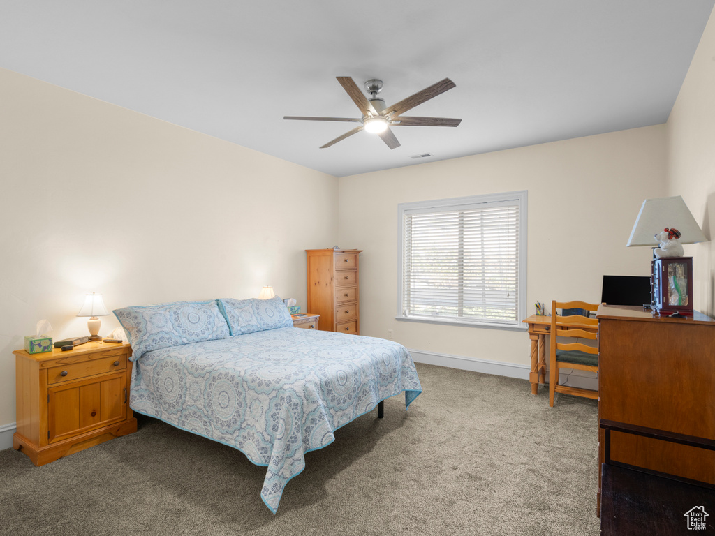 Carpeted bedroom featuring ceiling fan