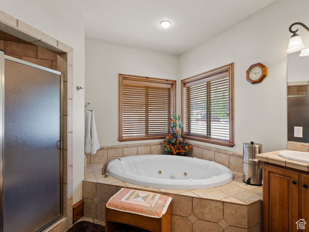 Bathroom featuring vanity and plus walk in shower