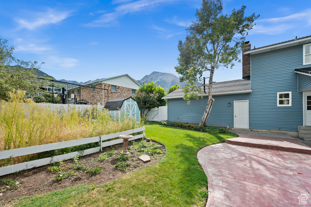 View of yard featuring a patio, a storage unit, and a mountain view