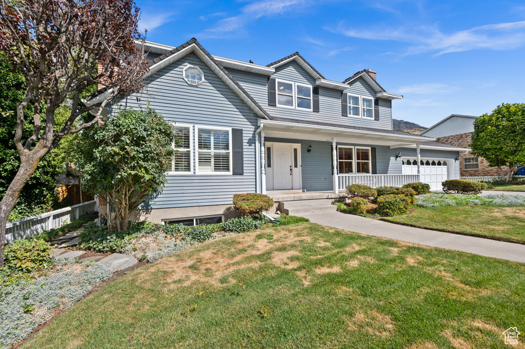 View of property featuring a front lawn and a porch