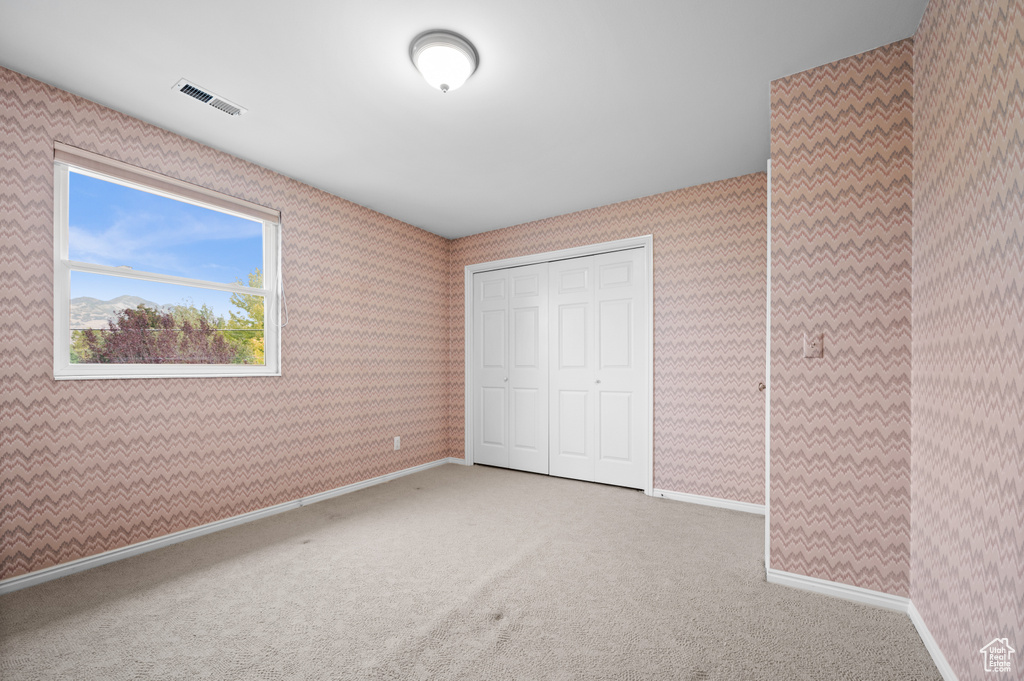 Unfurnished bedroom with a closet and carpet flooring