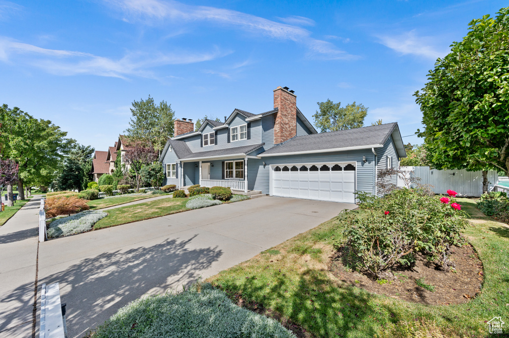 Cape cod-style house featuring a porch and a garage