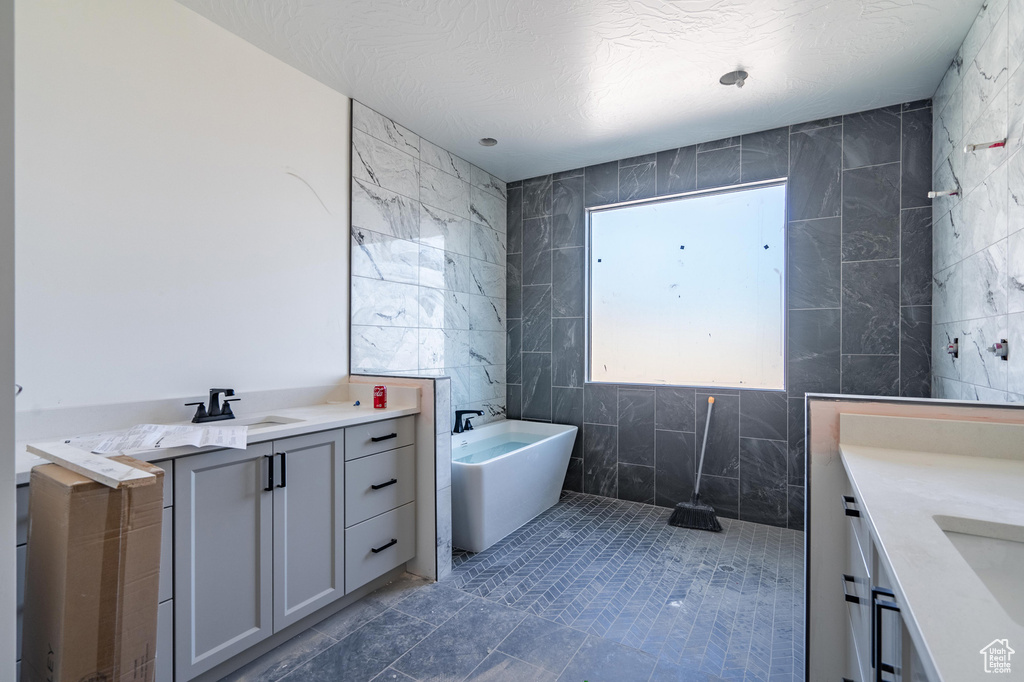 Bathroom featuring vanity, tile walls, and a textured ceiling