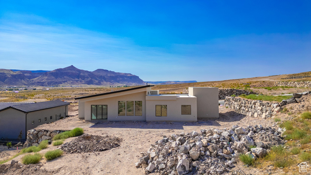 Back of property with a mountain view and a patio