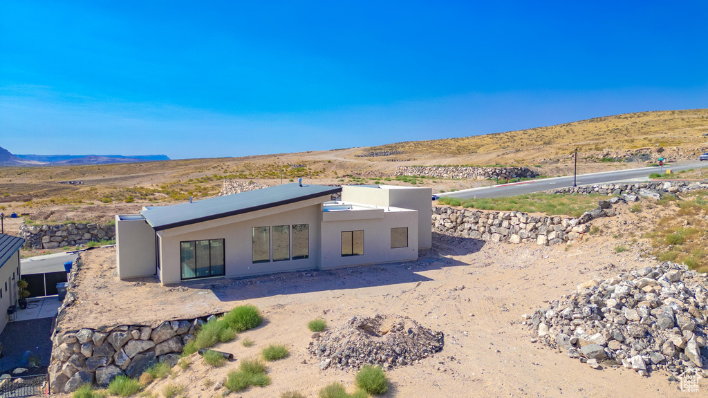 View of front of house with a mountain view and a patio area