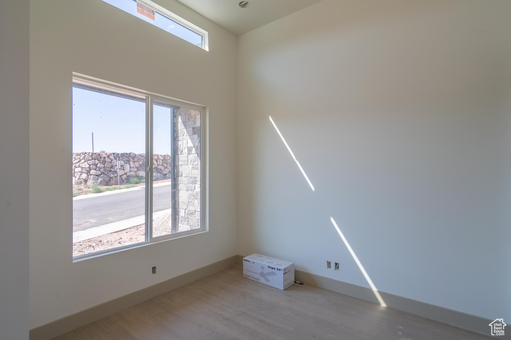 Unfurnished room featuring wood-type flooring and plenty of natural light