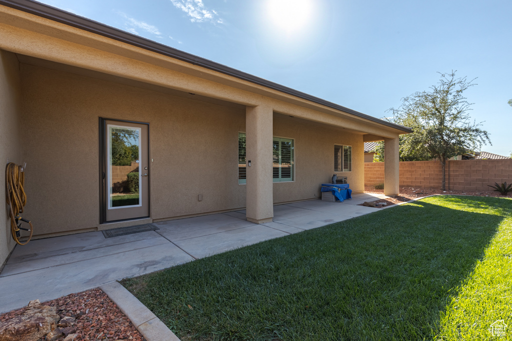 Back of property with a yard and a patio