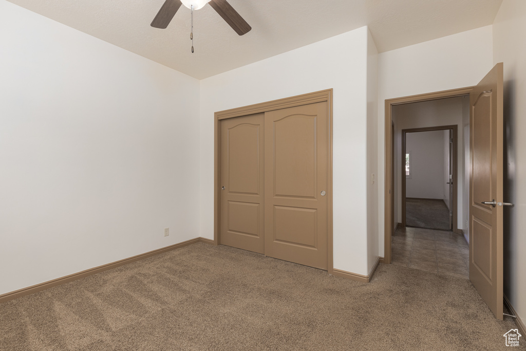 Unfurnished bedroom featuring carpet floors, a closet, and ceiling fan