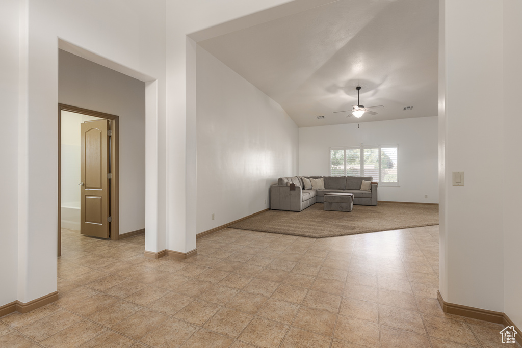 Unfurnished living room with ceiling fan and lofted ceiling