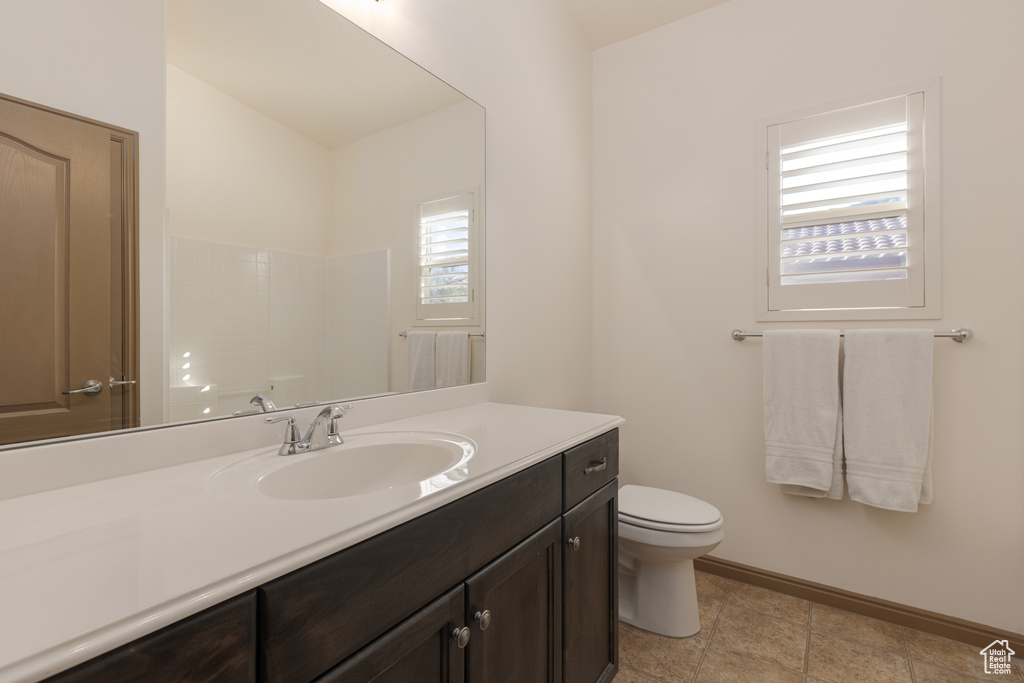 Bathroom featuring vanity, toilet, a shower, and tile patterned flooring