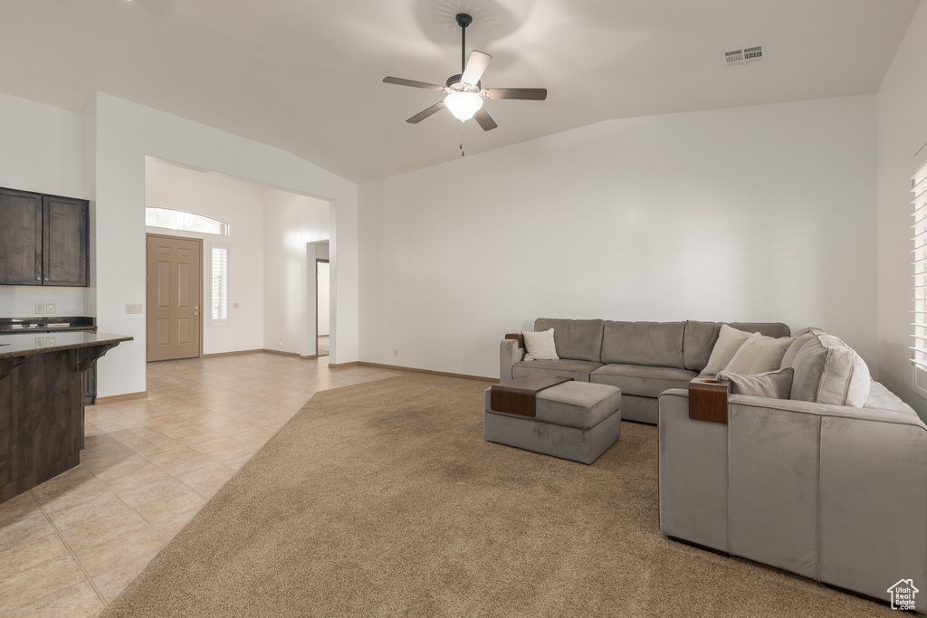 Living room featuring ceiling fan, lofted ceiling, a wealth of natural light, and light colored carpet