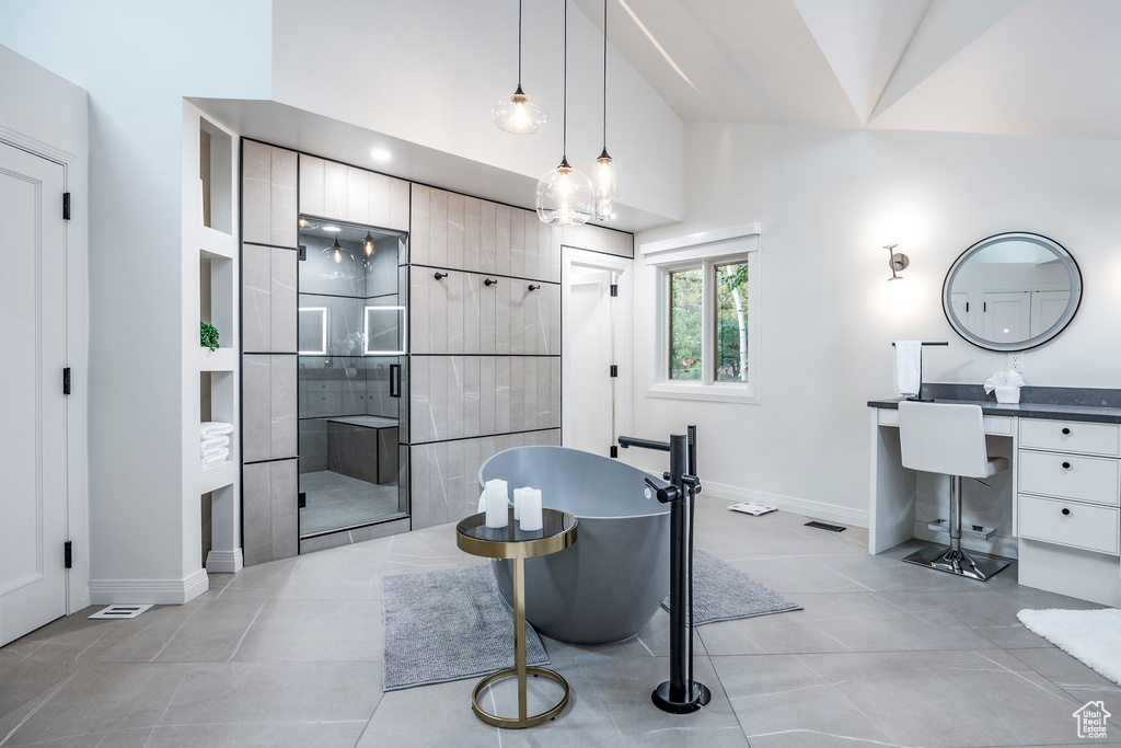 Bathroom featuring separate shower and tub, vanity, vaulted ceiling, and tile patterned floors