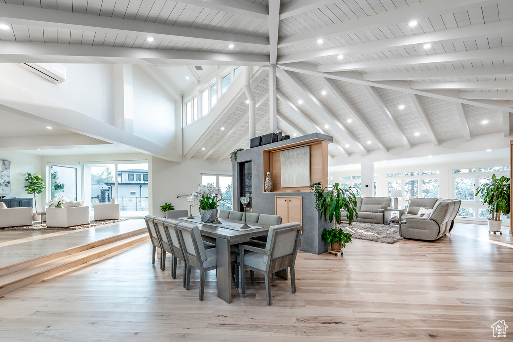 Dining space with high vaulted ceiling, a wealth of natural light, light hardwood / wood-style floors, and beamed ceiling