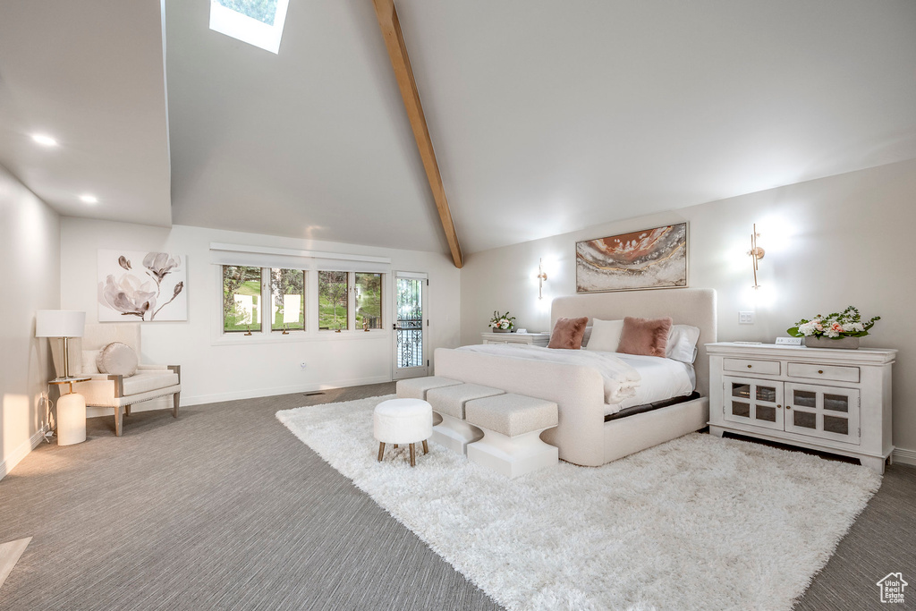 Carpeted bedroom featuring high vaulted ceiling, beam ceiling, and a skylight