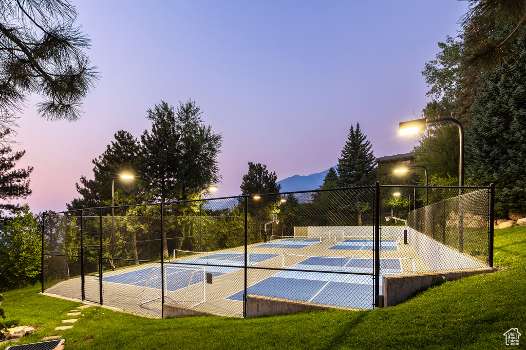 View of basketball court with a yard and tennis court