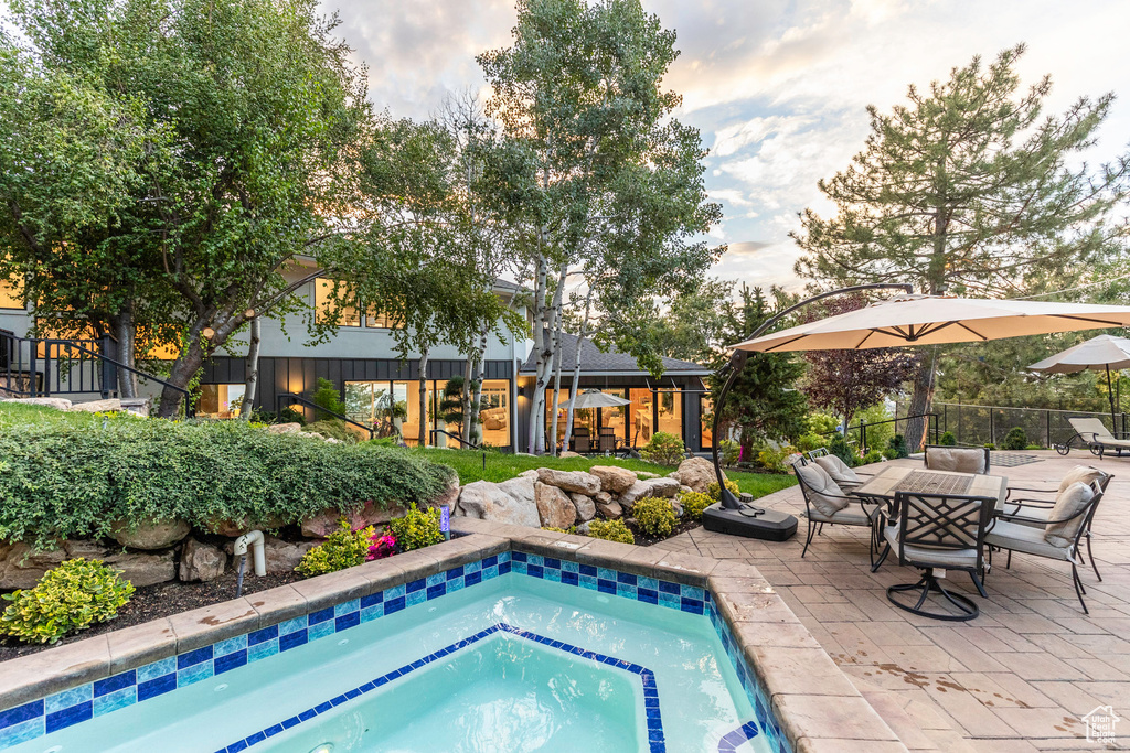 View of swimming pool featuring a patio and an in ground hot tub