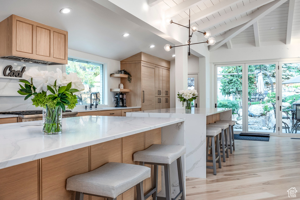 Kitchen with vaulted ceiling with beams, a chandelier, and a healthy amount of sunlight