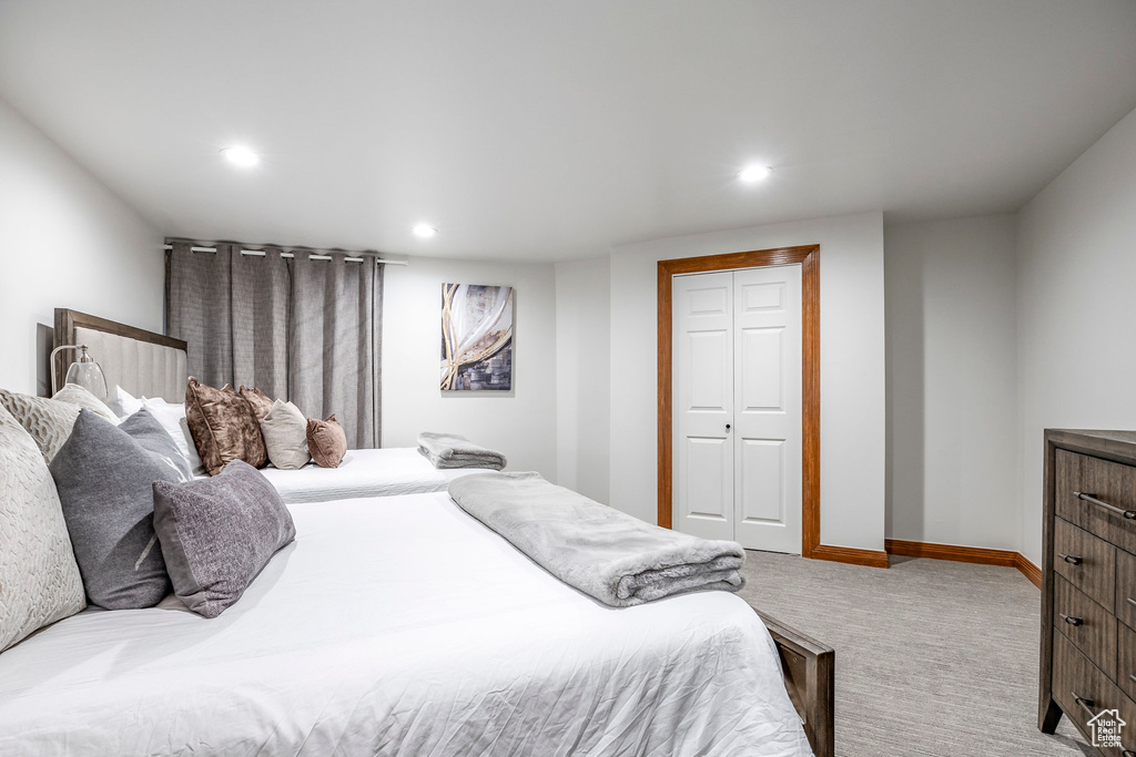 Bedroom featuring light carpet and a closet