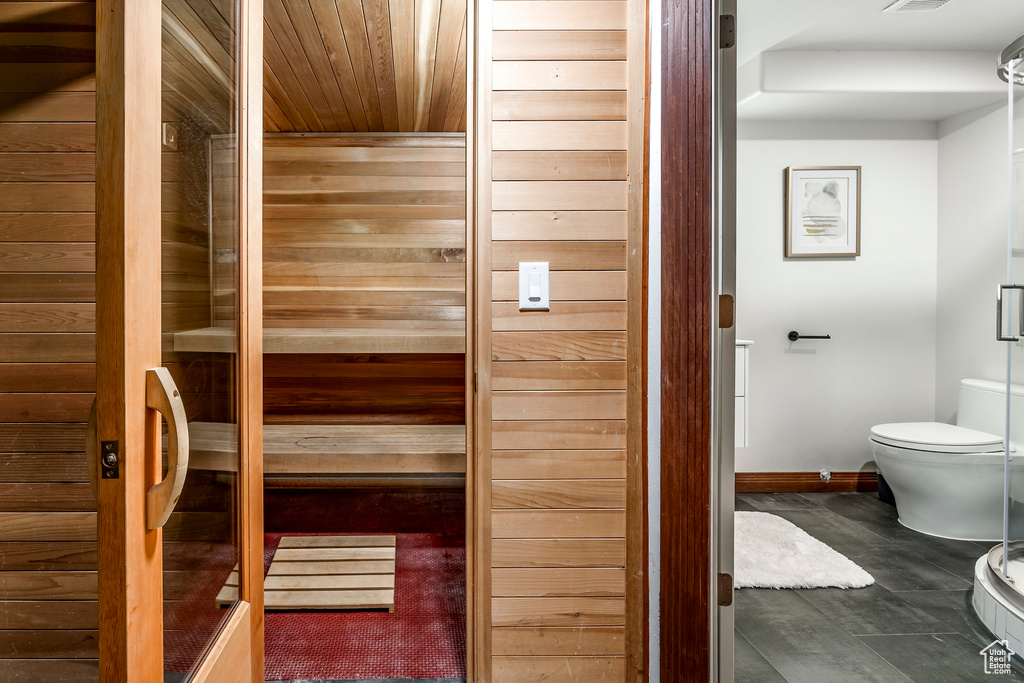 View of sauna with wood ceiling and tile patterned floors