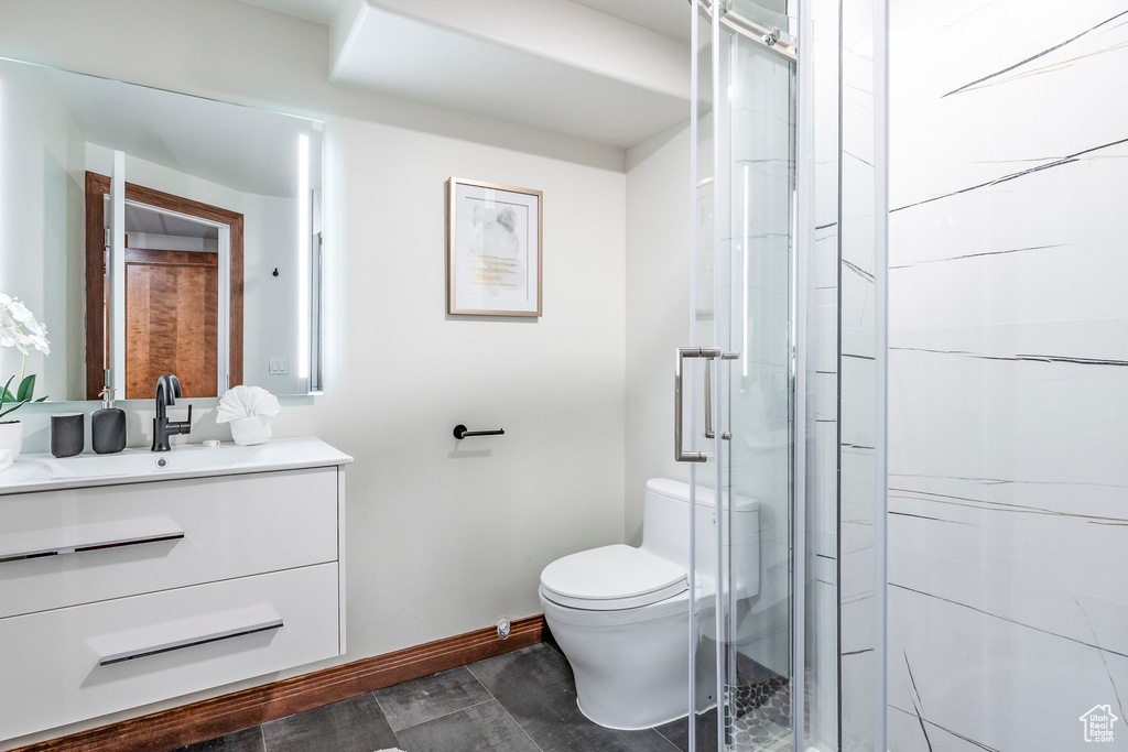 Bathroom featuring vanity, toilet, and an enclosed shower