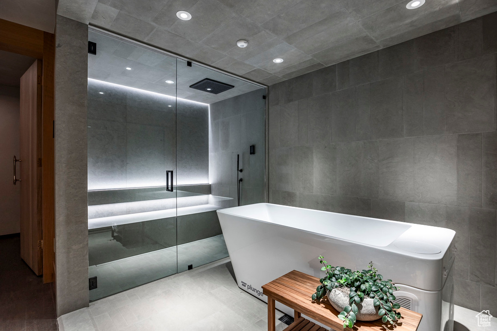 Bathroom featuring tile walls and independent shower and bath