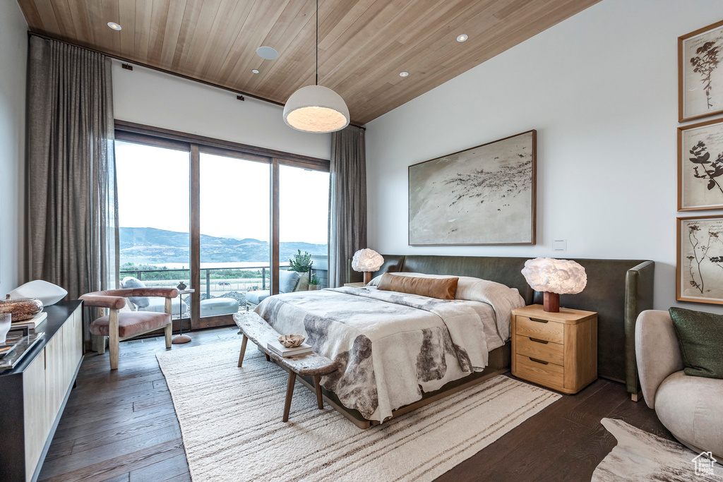 Bedroom featuring wooden ceiling, a mountain view, dark hardwood / wood-style floors, and access to exterior