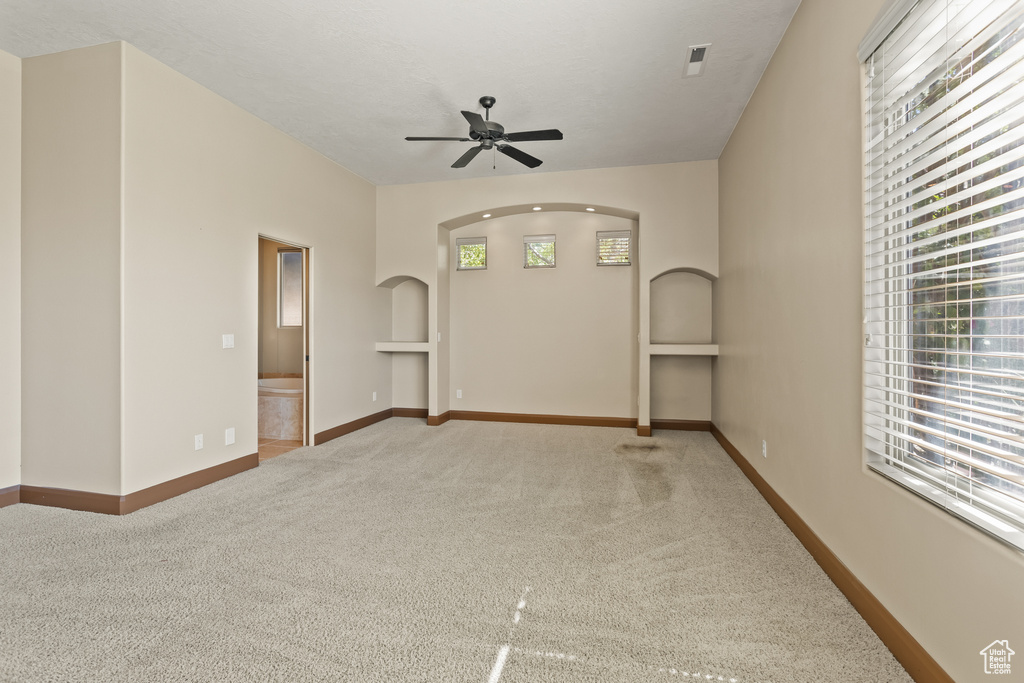 Carpeted empty room with ceiling fan