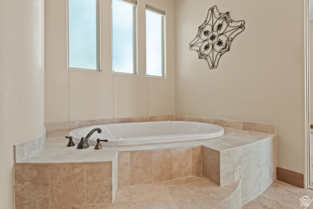 Bathroom with tile patterned flooring and a relaxing tiled tub