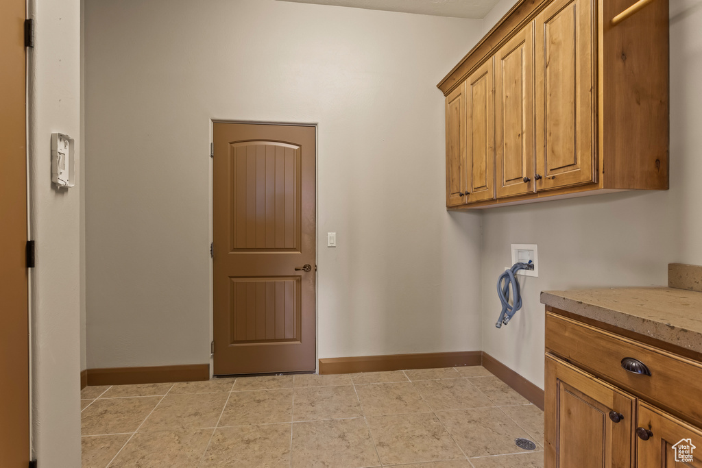 Laundry area featuring cabinets, washer hookup, and light tile patterned flooring