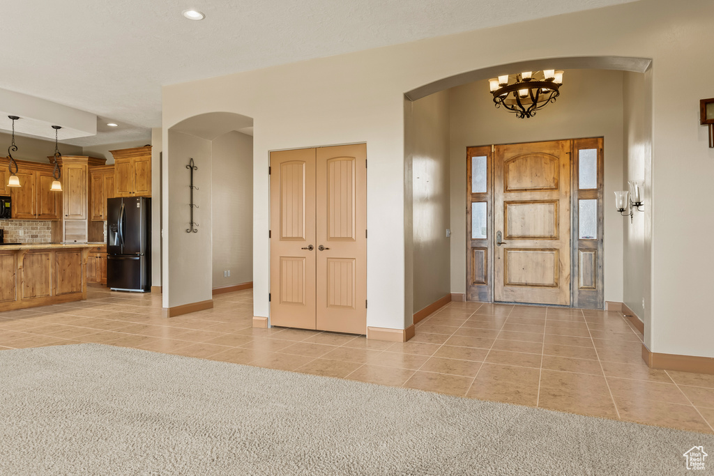 Entryway featuring an inviting chandelier and light tile patterned flooring